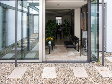 Udsigt fra Travertins rustikke terrasse til en stilfuld udestue