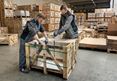 To medarbejdere pakker en kasse med sten
