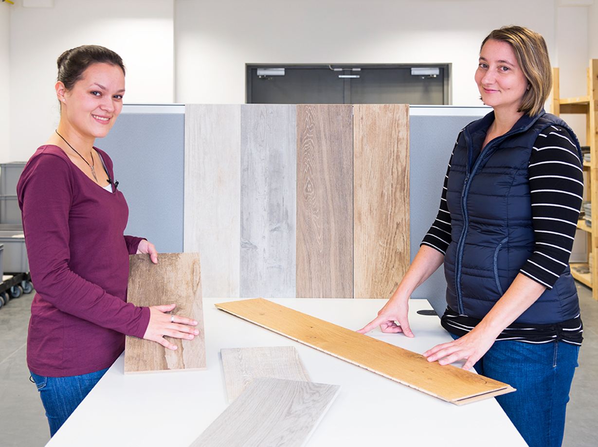 To medarbejdere viser forskellige fliser i trælook