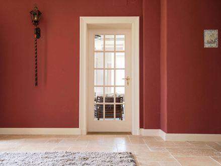 Indgangsparti med travertinfliser og røde vægge