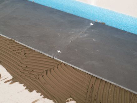 Fugekryds som afstandsstykke mellem to skiferfliser