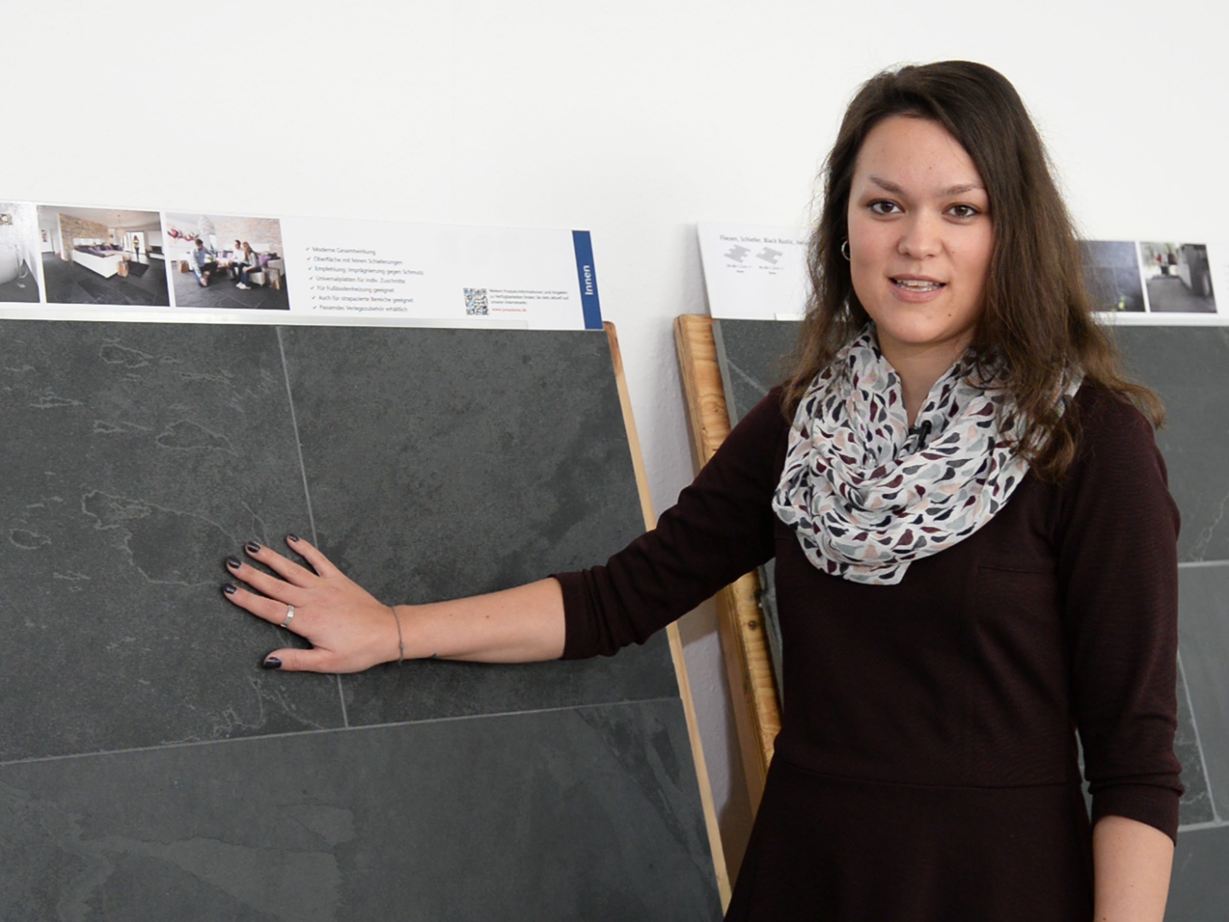 Medarbejder står foran eksempler på skiferplader