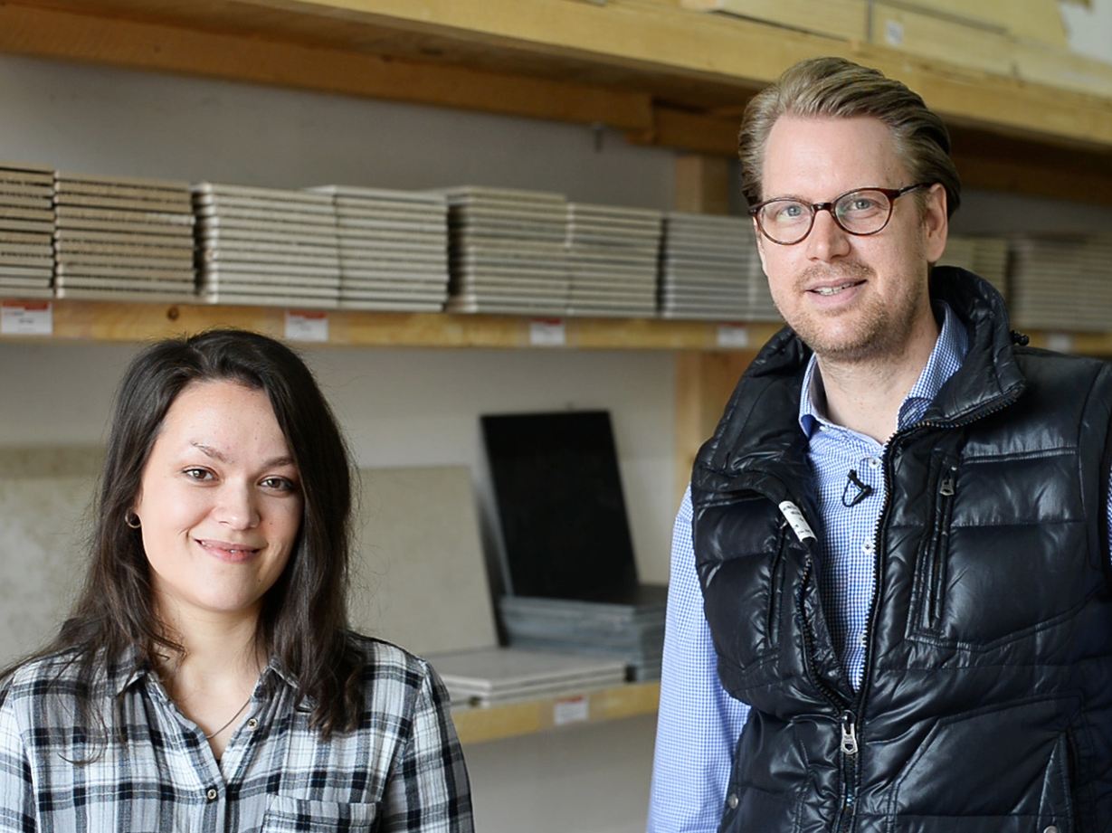 En medarbejder foran en hylde med prøvefliser