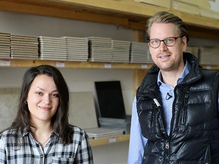 En medarbejder foran en hylde med prøvefliser