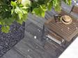 Udsigt i fugleperspektiv over granitterrasse med træmøbler