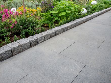 Sti med granitplade Padang Dark og tilstødende blomsterbed