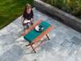 Slap af med stil på en Afyon Grey-terrasse! Kvinde sidder ved et træbord på en terrasse med marmorplader