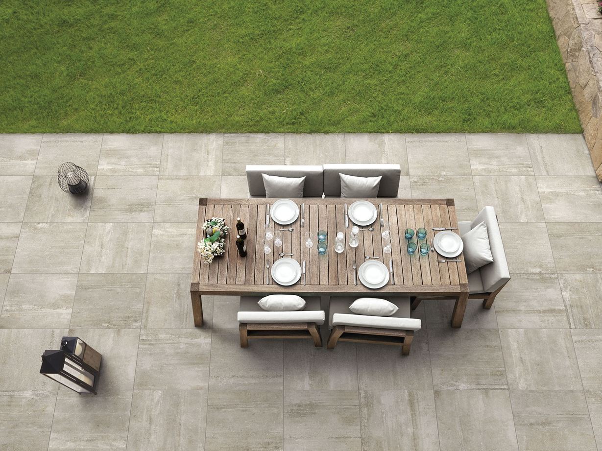 Moderne udendørs paradis: Beton og sand Beigefarvede paneler med betonlook Betonsand med terrasse, bord og stole