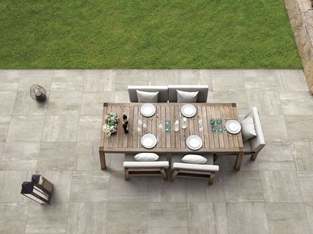 Beigefarvede paneler med betonlook Betonsand med terrasse, bord og stole