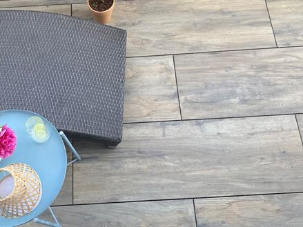 Terrassefliser i porcelænsstentøj med træeffekt Canada Lodge med liggestol og bord