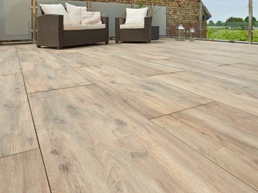 Terrasse med moderne rattanmøbler og træbeklædning Canada Lodge terrasse fra frøperspektiv