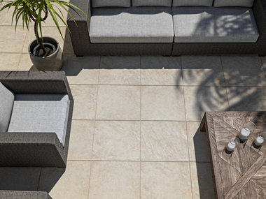 Topbillede af terrasse med Classic Beige-plade med kvartseffekt og havemøbler