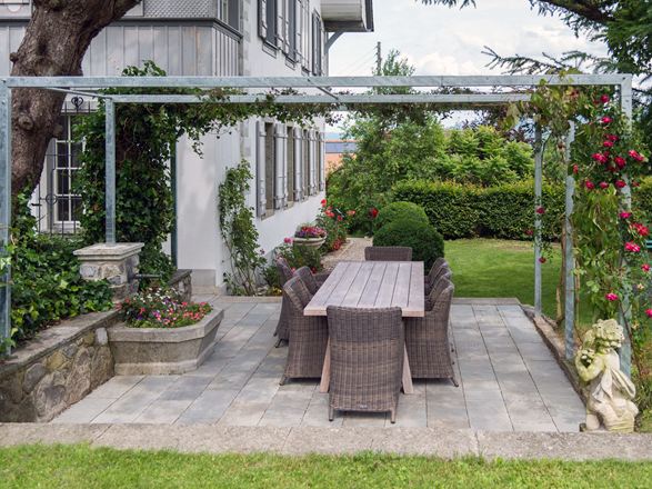 Kandla Grey sandstensplade på en terrasse med pergola og tilstødende græsplæne