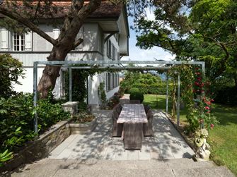 Terrasse med naturstensplader af grå sandsten i en naturhave