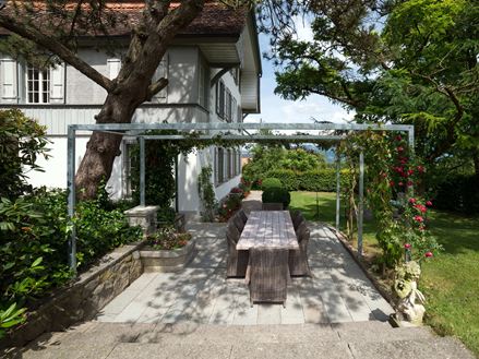Terrasse med naturstensplader af grå sandsten i en naturhave