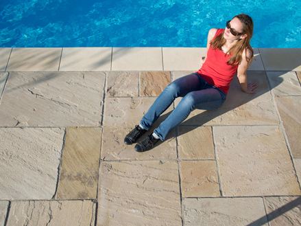 Aftensol på sandstenspladerne Yellow Mint med en kvinde ved poolen