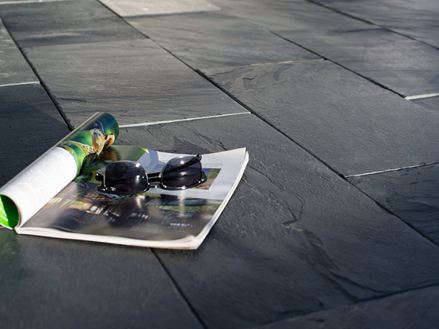 Et magasin og solbriller på skiferplader i solen