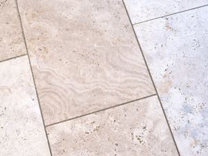 Nærbillede af travertinplader til udendørs brug i en blød beige farve