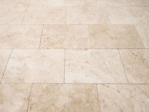 Naturstensgulv lagt i travertin i en blød beige farve