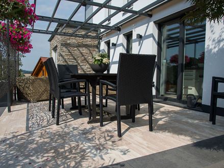 Terrasse med sorte møbler og træ-effekt Natura travertin