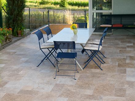 Noce-terrasse i travertin med havebord