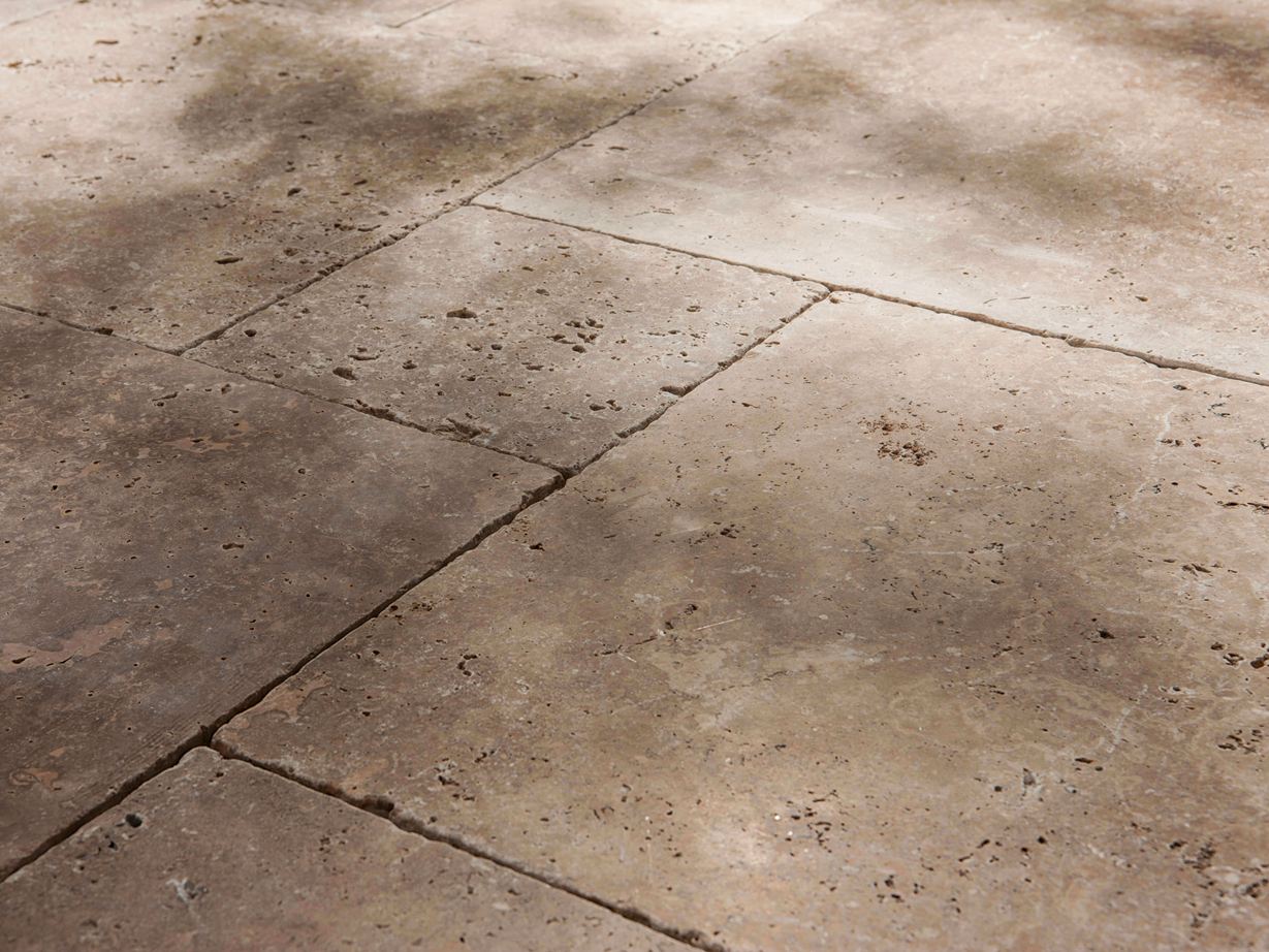 Rustik og naturlig med mange porer Travertinplader Noce, tumlet, side nærbillede med halvskygge