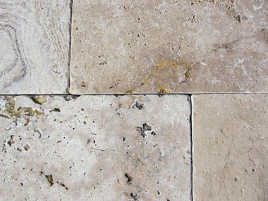 Nærbillede af tumlede travertinplader med karakteristiske fordybninger