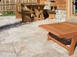 Rustik terrasse med rustikke travertin- og træmøbler