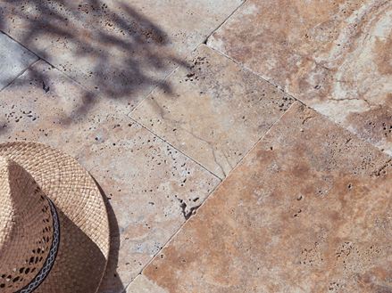 Travertin Scabas-terrasse i sollys med stråhat