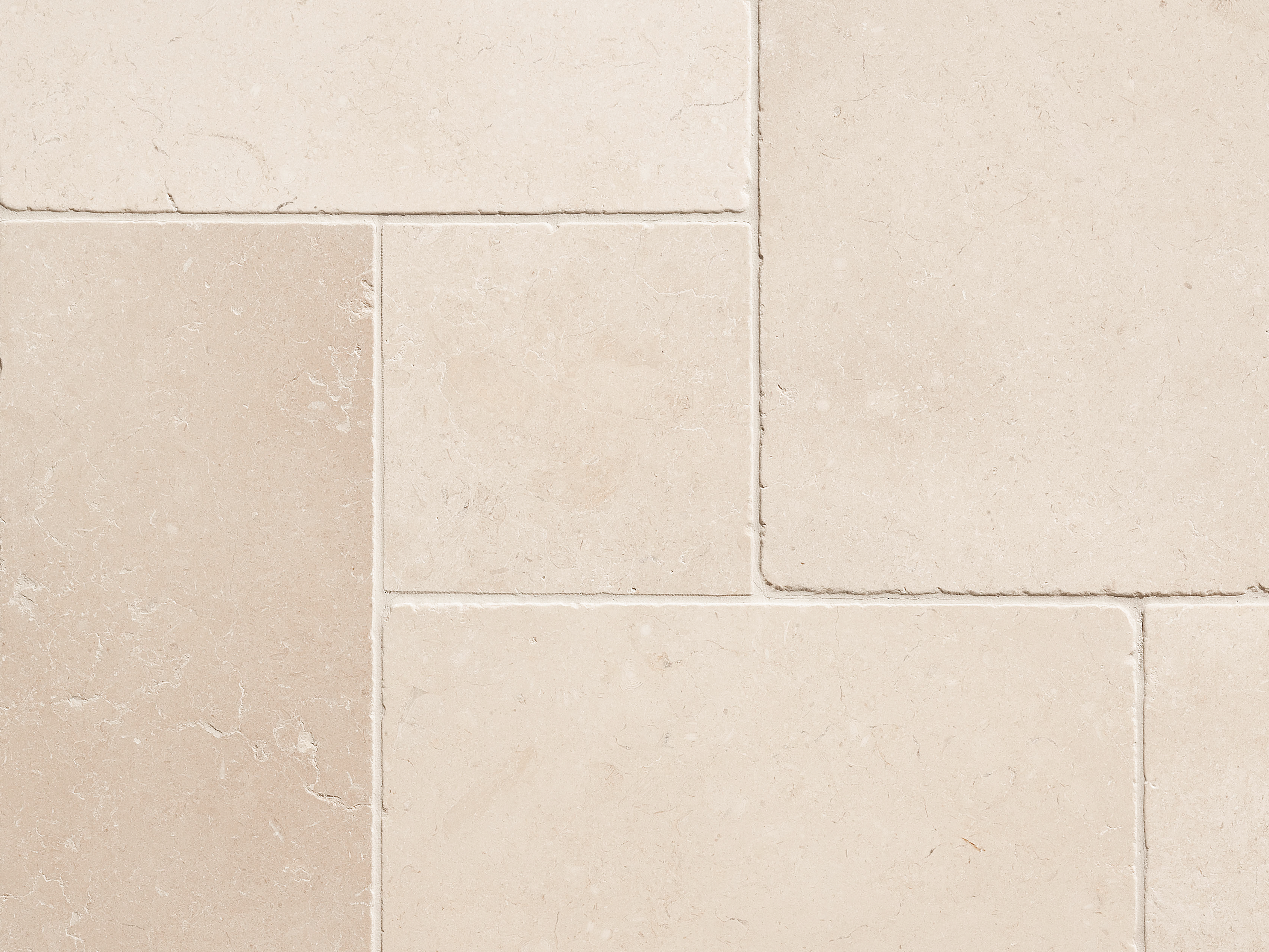 Nærbillede af beige kalkstensfliser med smal fuge