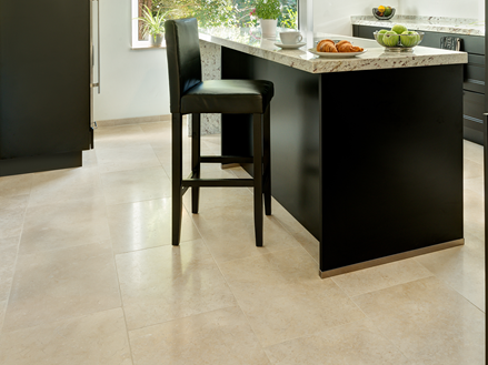 Køkken med moderne sorte møbler og lyse beige kalkstensfliser på gulvet