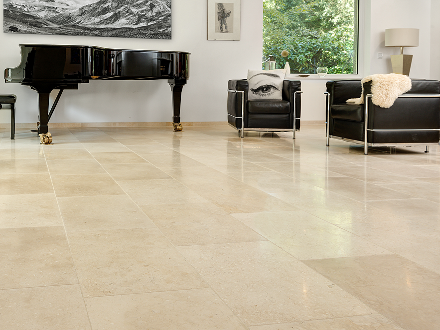 Lys stue med beige kalkstensgulv, moderne sofamøbler og et flygel