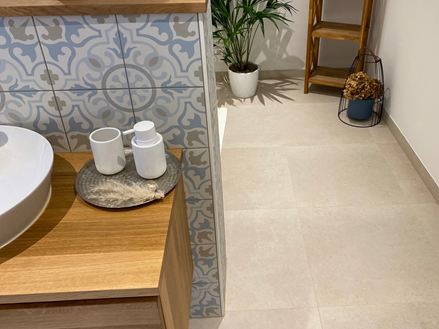 Badeværelse med træelementer og dekorative planter, Sevilla Cream fliser i kalkstenslook som gulvbelægning
