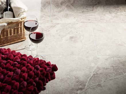 To vinglas står ved siden af kurv med vinflaske og rød pude på Silver Shadow polerede marmorfliser
