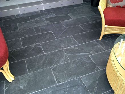 Kurvemøbler med røde hynder på mørk Black Rustikke skiferfliser med hvide fuger