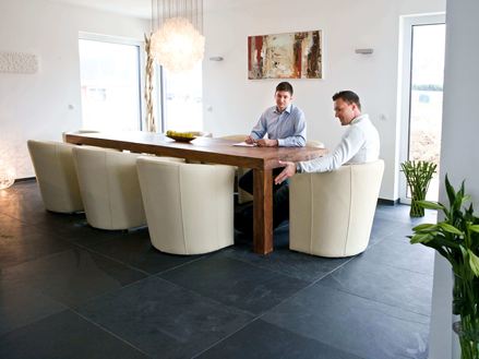 Spisebord med hvide lænestole og to personer på Mustang skiferflise i mørkegrå