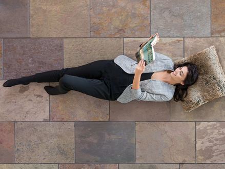 Kvinde ligger på farvede skiferfliser Peacock Multi Color og læser