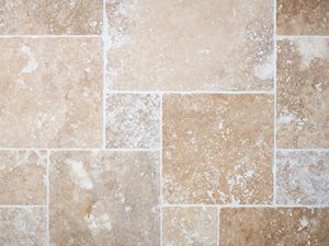 Fugleperspektiv af lagte og fugede travertinfliser i beige og brun