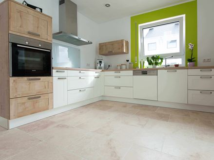 Køkken i hvidt med træelementer og grøn vinduesramme på Light travertinfliser med tumlet, ujævn overflade