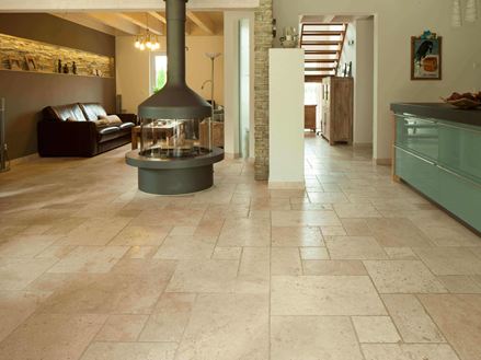 Stue og spisestue med siddeområde og køkkenbord på tumlede Light travertinfliser