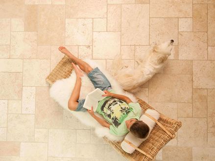 Dreng læser i en liggestol på Light travertinfliser lagt i et romersk bånd