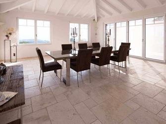 Spisestue med højt til loftet, bord og stole på travertin Light i romersk bindingsværk