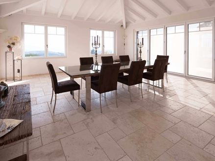 Spisestue med højt til loftet, bord og stole på travertin Light i romersk bindingsværk