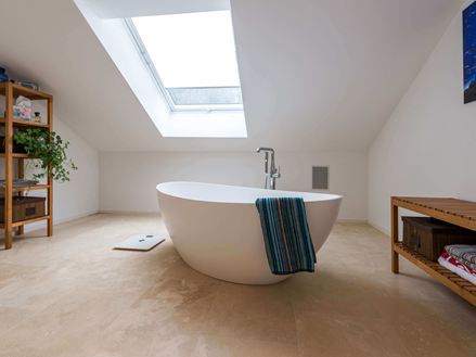 Badeværelse med Travertine Medium Line, fritstående badekar og håndklæde