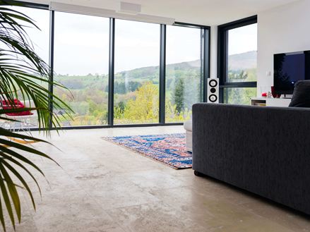 Stue med Medium Line travertinfliser og stor vinduesfront