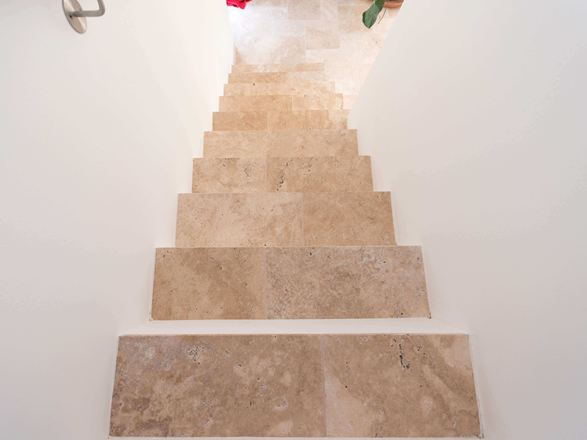 Trappe med hvide vægge og travertin Medium som trædeplader