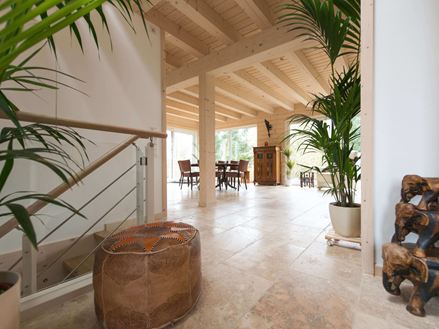 Rustikke fliser i travertin i lysgennemstrømmede stuer med planter