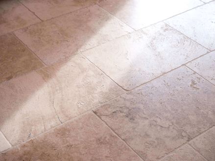 Rustikke fliser i travertin, set fra siden med lys og skygge