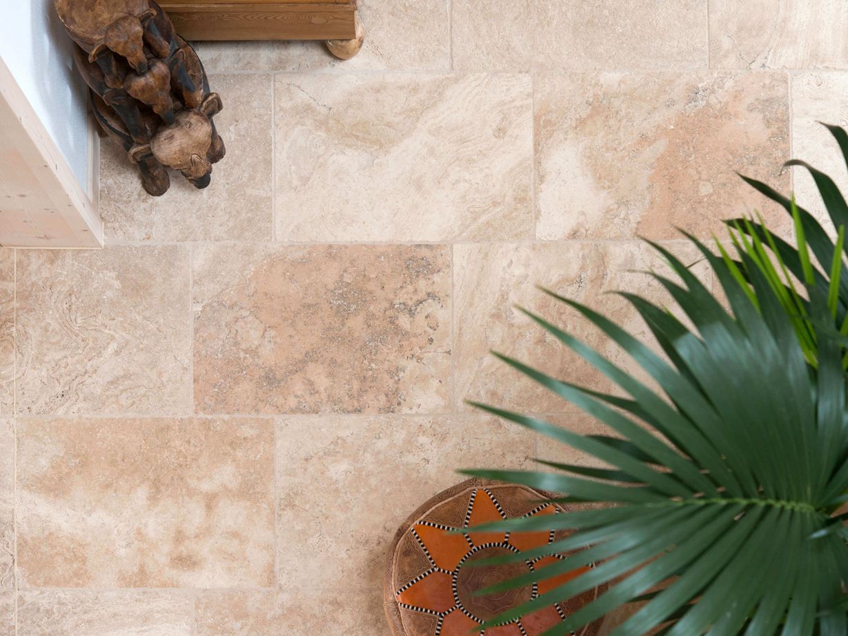 Rustic travertin flise: med typisk, charmerende porestruktur Fugleperspektiv af lagt travertin flise Rustic med planter og trætilbehør