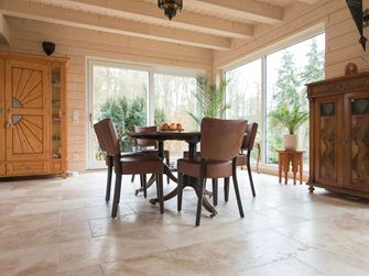 Spiseplads med træmøbler og rustikt travertingulv